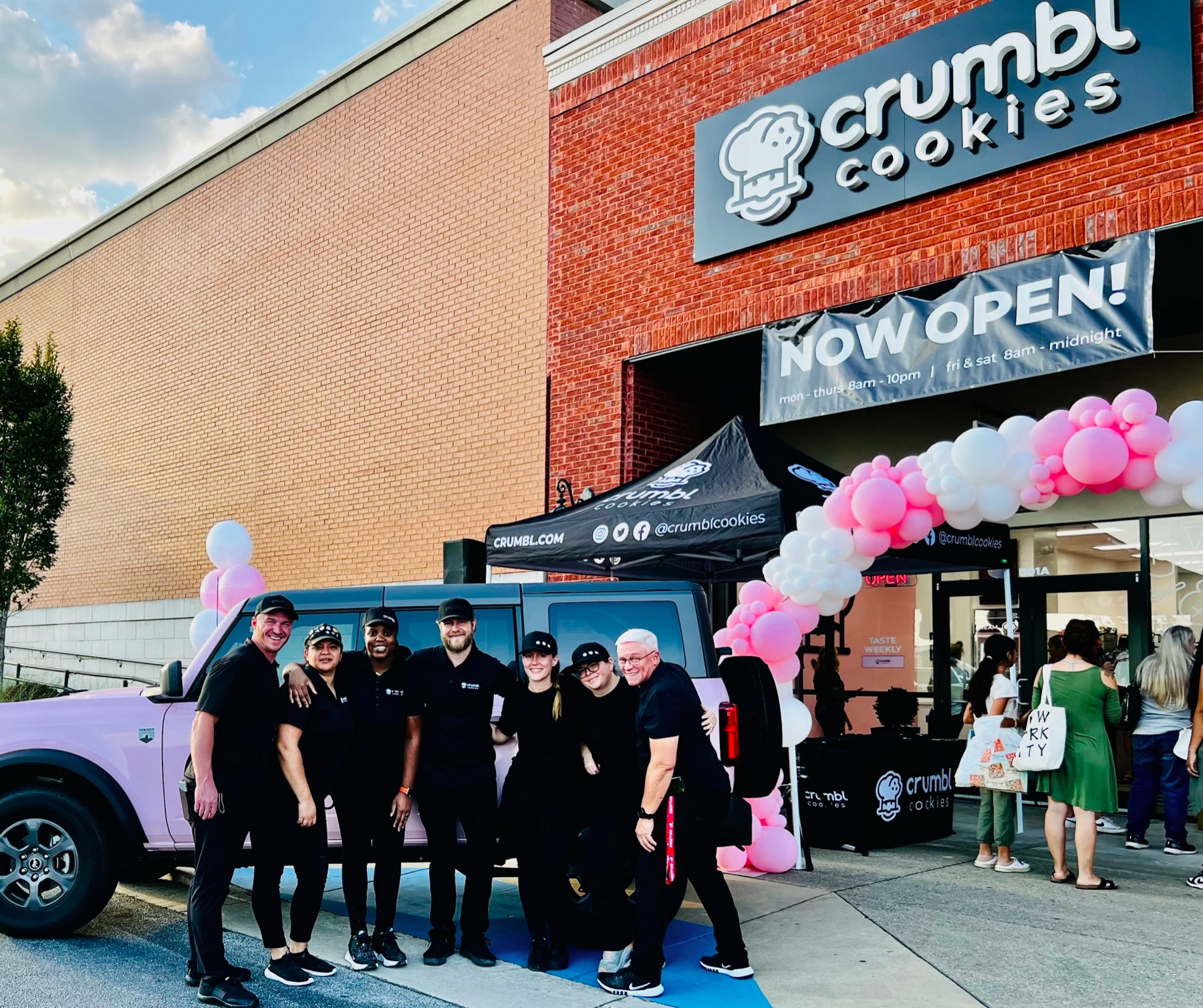The Vision Food Group team gathered in front of a Crumbl Cookies bakery on opening day